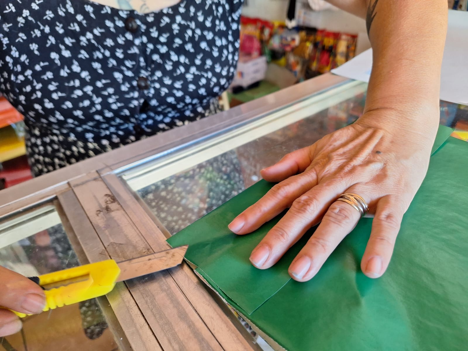 Manos forrando un cuaderno escolar con papel de color